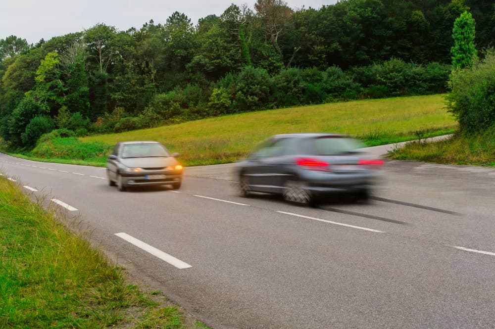 Two car on the rural road about to head on collision