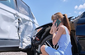 Sad female driver telling on Cell phone on street side about car accident